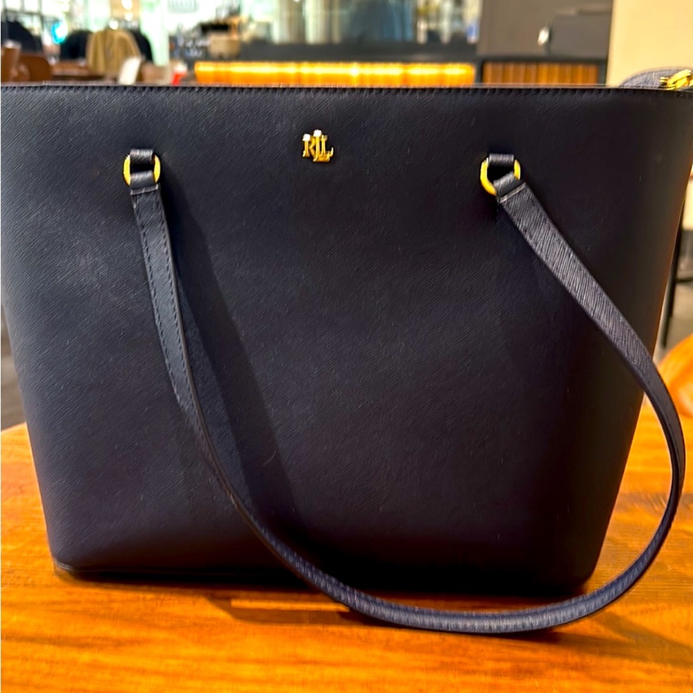 Stylish and timeless, this is a navy blue leather, Ralph Lauren tote.